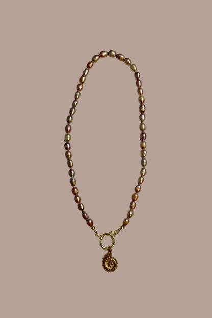 Collar de perlas con colgante de caracola, todo en acero inoxidable.