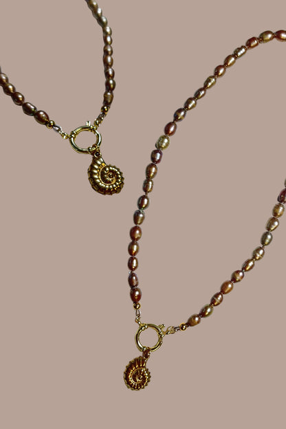 Collar de perlas con colgante de caracola, todo en acero inoxidable.