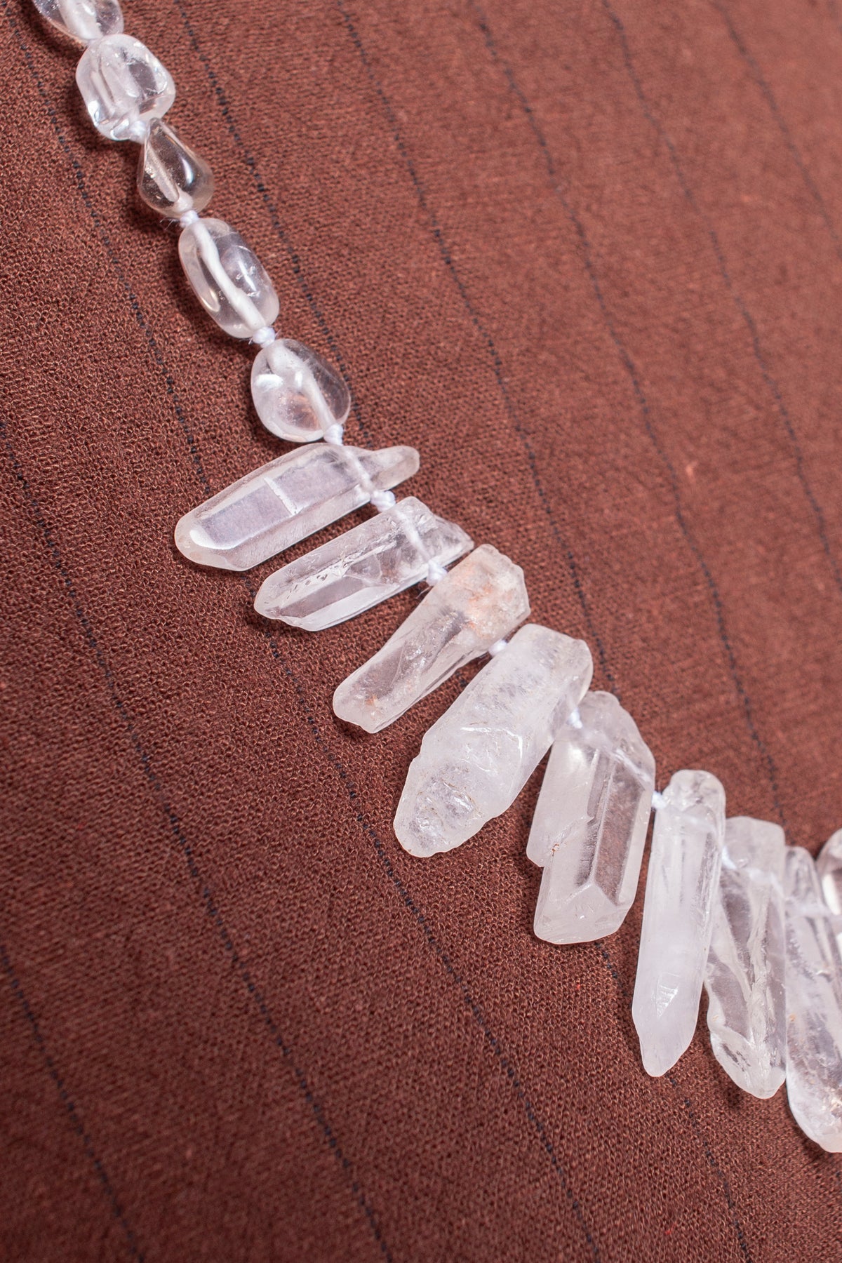 Collar artesanal en cuarzo blanco de brillo natural, cada pieza tallada a mano para capturar la pureza y la energía del mineral. 